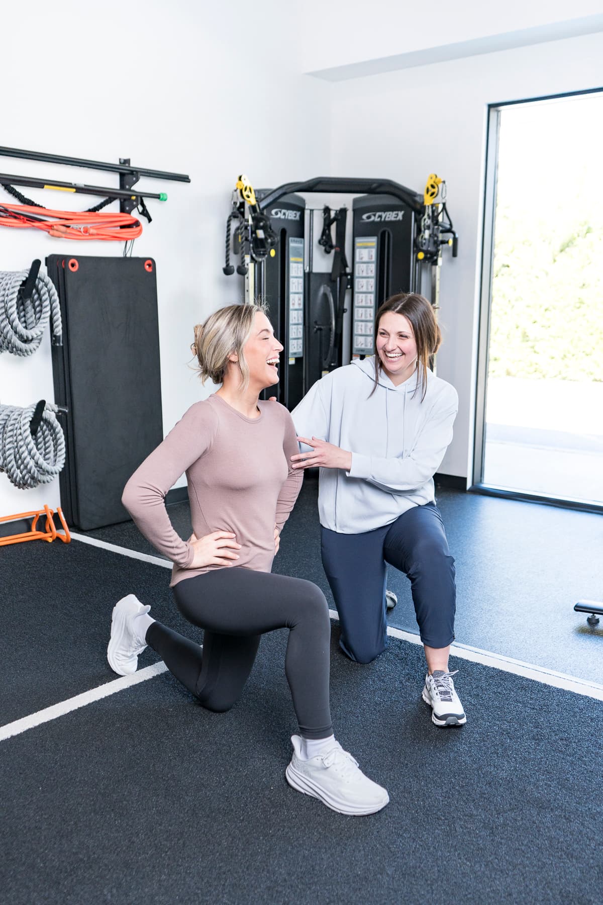 Dr. Abby Dante coaching a patient through a kneeling stretch in the clinic's training area