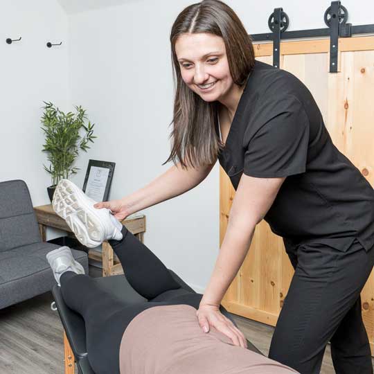 Dr. Abby Dante stretching a patient's leg on the treatment table